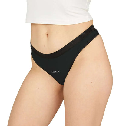 Close-up of woman wearing black bikini bottoms with white crop top on white background